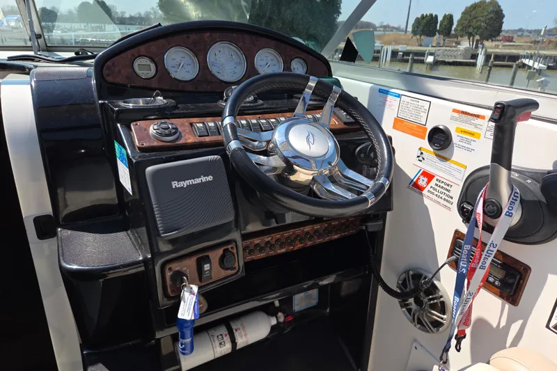 Slide: The Image of Control panel of a 2014 Rinker 290 Express Cruiser with steering wheel and navigation equipment. - 11