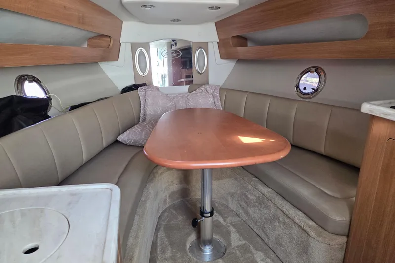 Slide: The Image of Interior of 2014 Rinker 290 Express Cruiser with cozy seating and wooden table. - 17