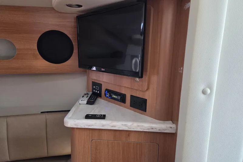 Slide: The Image of 2014 Rinker 290 Express Cruiser interior with TV and entertainment system. - 18