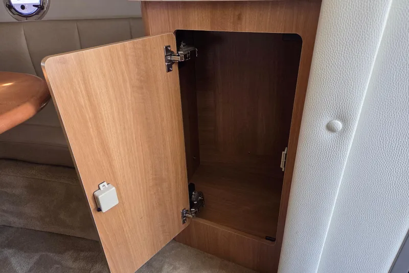 Slide: The Image of Open wooden cabinet inside 2014 Rinker 290 Express Cruiser boat interior. - 19