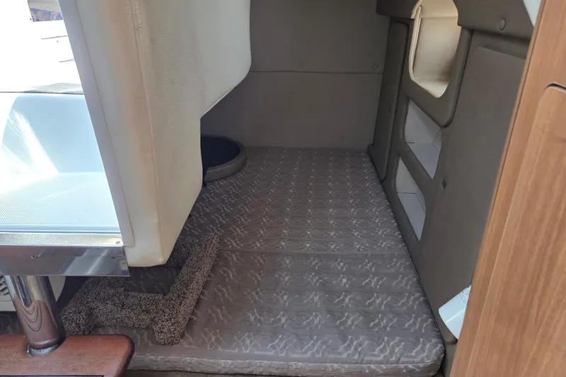 Slide: The Image of 2014 Rinker 290 Express Cruiser cabin interior with cushioned sleeping area. - 20