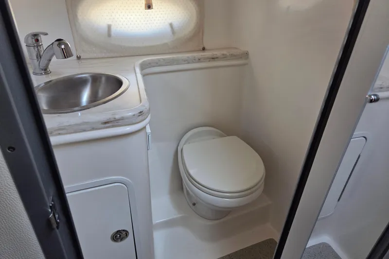 Slide: The Image of 2014 Rinker 290 Express Cruiser bathroom with sink and toilet. - 21