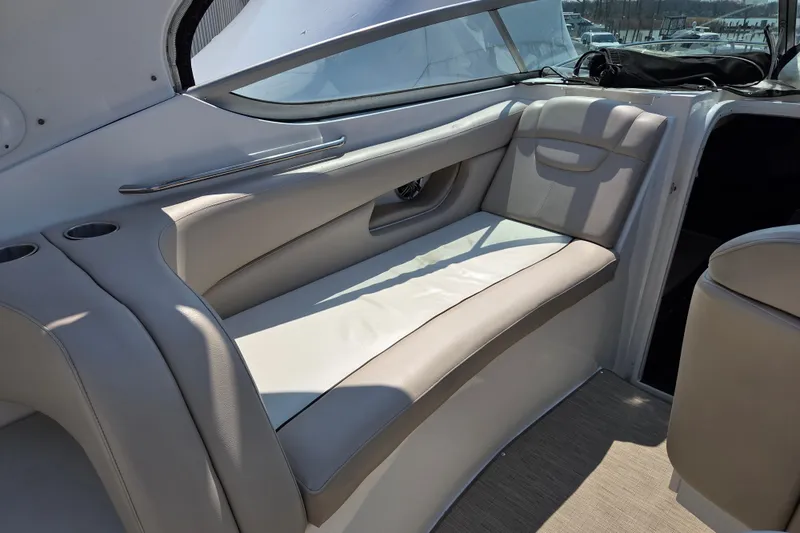 Slide: The Image of Interior seating of 2014 Rinker 290 Express Cruiser with beige upholstery and cup holders. - 27