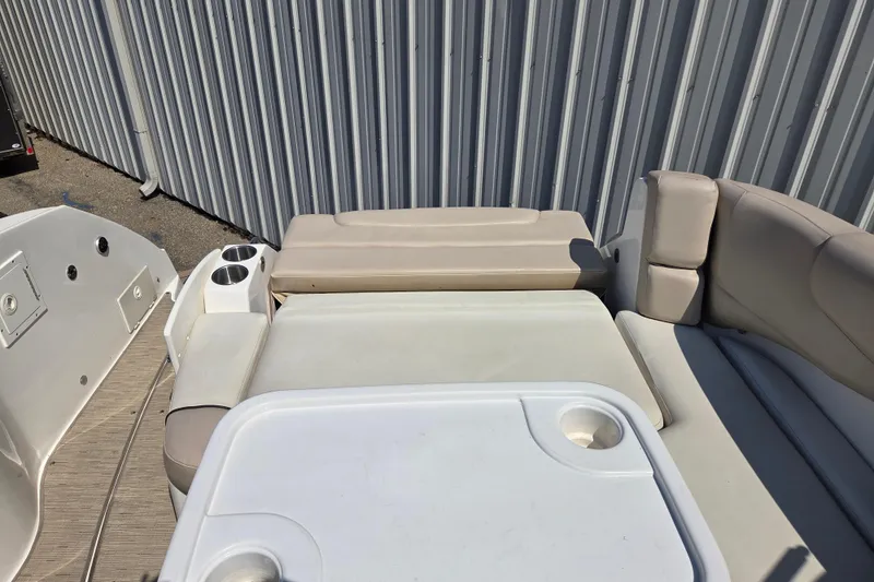 Slide: The Image of 2014 Rinker 290 Express Cruiser interior with seating and table, featuring cup holders. - 30