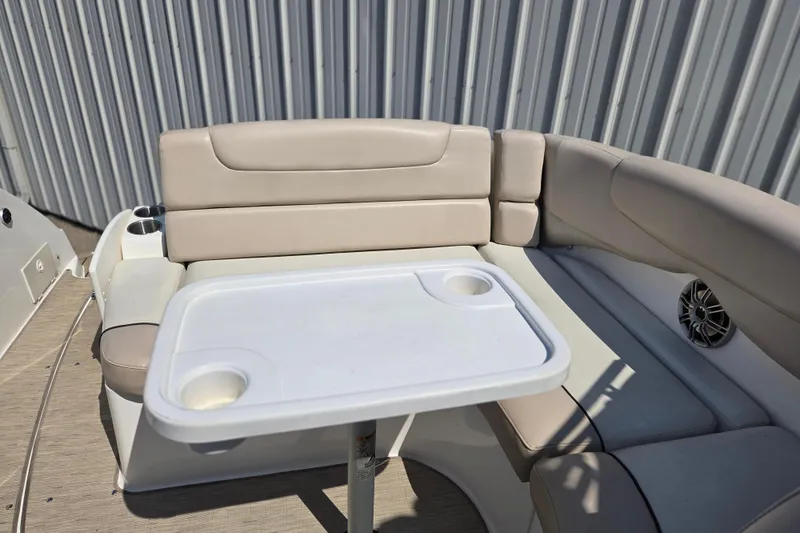 Slide: The Image of 2014 Rinker 290 Express Cruiser interior with beige seating and a white table. - 32