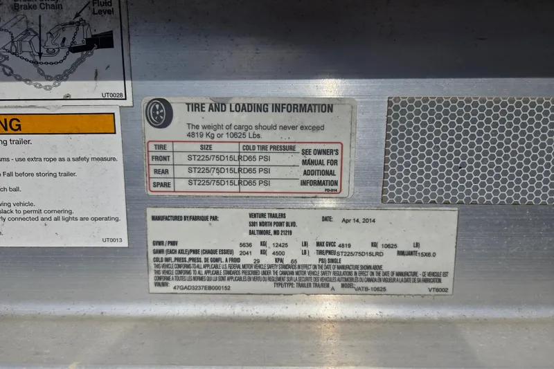 Slide: The Image of Tire and loading information label on a 2014 Rinker 290 Express Cruiser trailer. - 34