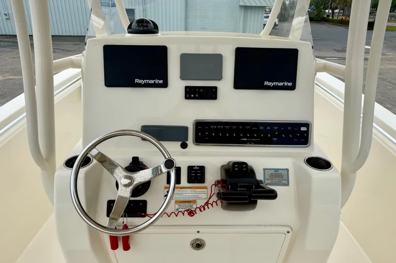 Slide: The Image of 2018 Cobia 261 Center Console helm with Raymarine electronics and steering wheel. - 10
