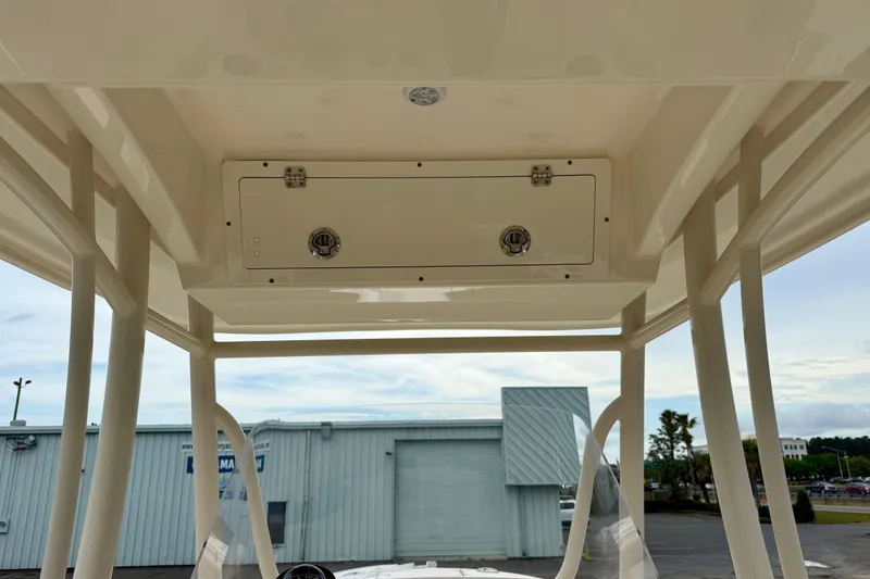 Slide: The Image of 2018 Cobia 261 Center Console boat's overhead storage compartment and T-top structure. - 11