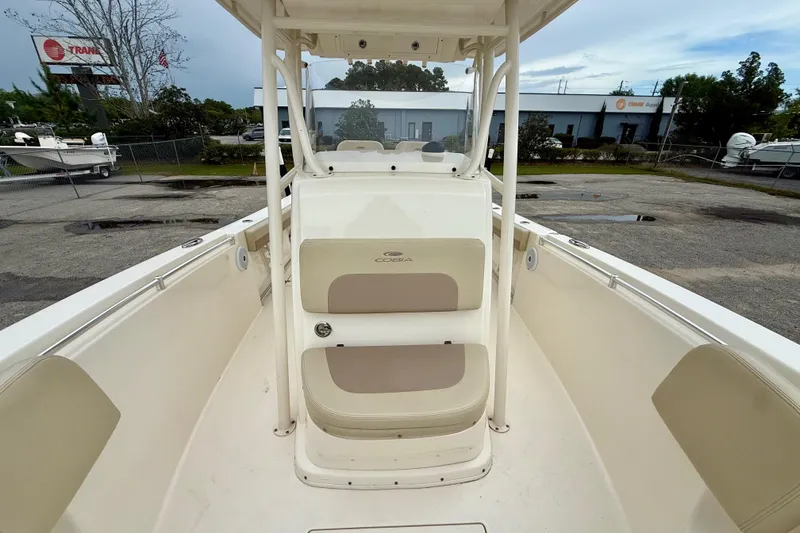 Slide: The Image of 2018 Cobia 261 Center Console boat with beige seating, parked outdoors. - 12