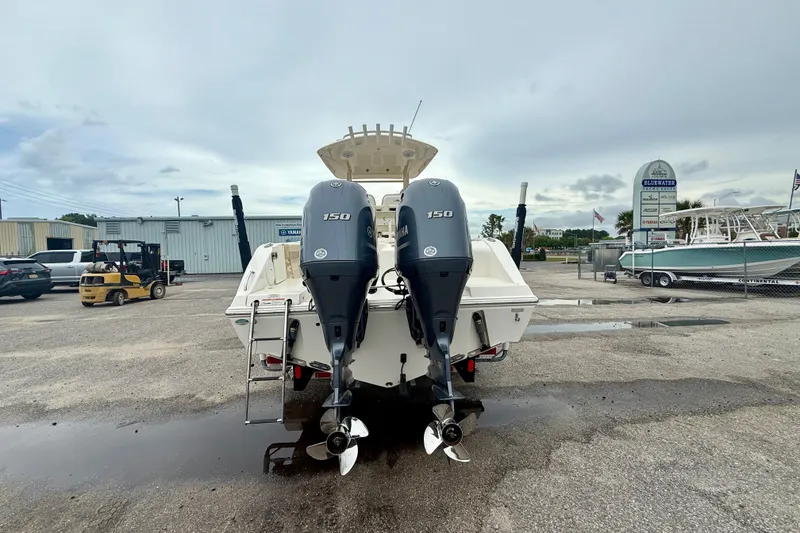 Slide: The Image of 2018 Cobia 261 Center Console boat with twin Yamaha 150 engines in a marina setting. - 2