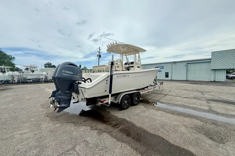 Slide: The Image of 2018 Cobia 261 Center Console boat on trailer with Yamaha engine in parking lot. - 3