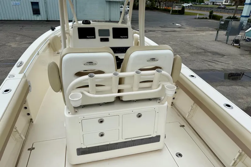 Slide: The Image of 2018 Cobia 261 Center Console boat interior with helm, rod holders, and storage compartments. - 7
