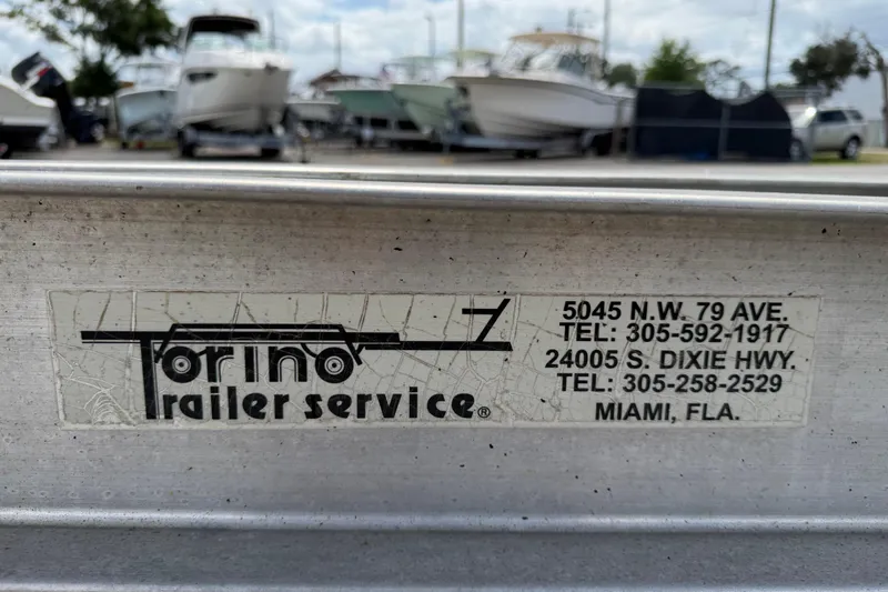 Slide: The Image of Sticker for Torino Trailer Service with contact details, Miami, Florida. Background shows boats, including a 2006 Ocean Runner 2900 C/C Open Fisherman. - 23