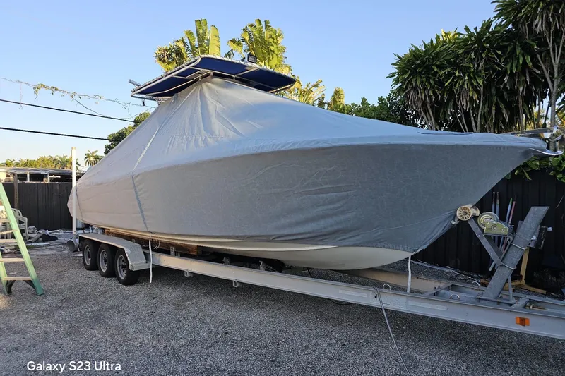 Slide: The Image of Covered 2006 Ocean Runner 2900 C/C Open Fisherman boat on trailer, surrounded by tropical foliage. - 3