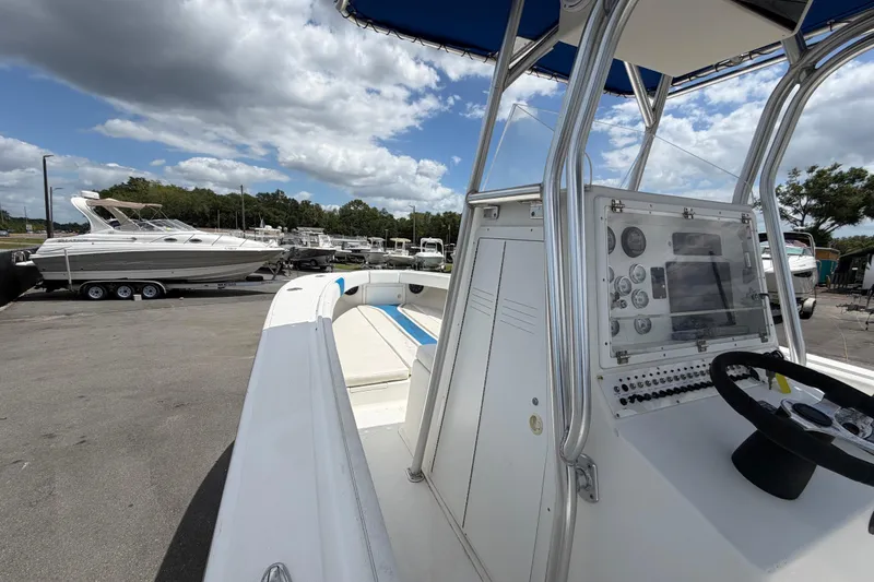Slide: The Image of 2006 Ocean Runner 2900 C/C Open Fisherman boat with control panel, docked under cloudy sky. - 37