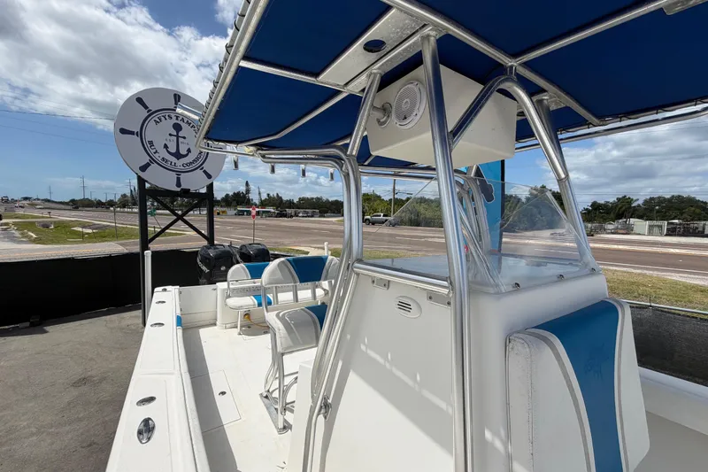 Slide: The Image of 2006 Ocean Runner 2900 C/C Open Fisherman boat with blue canopy, displayed outdoors. - 54