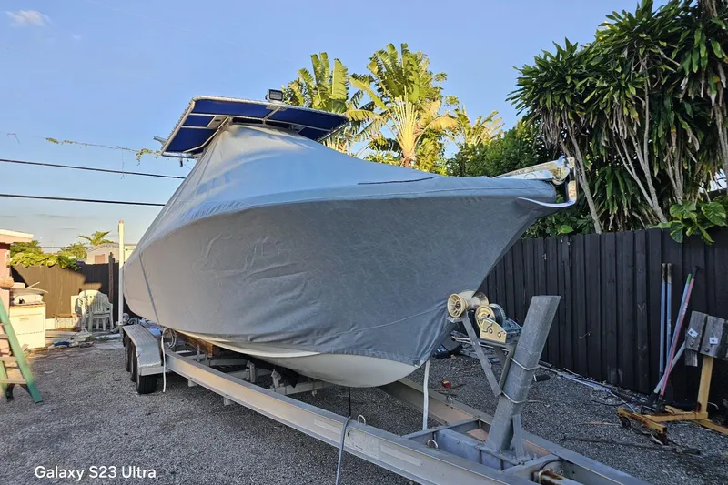 Slide: The Image of Covered 2006 Ocean Runner 2900 C/C Open Fisherman boat on trailer, surrounded by tropical foliage. - 8