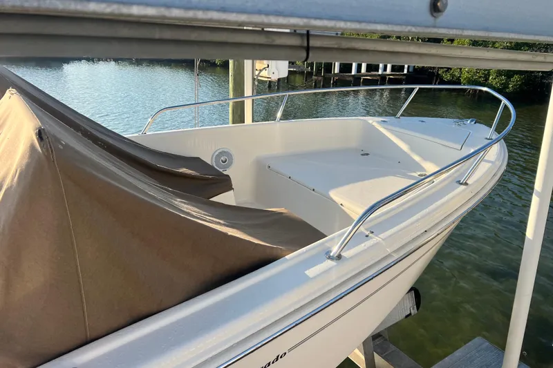 Slide: The Image of 2018 Scout 175 Sport Dorado boat docked by the water, partially covered. - 4