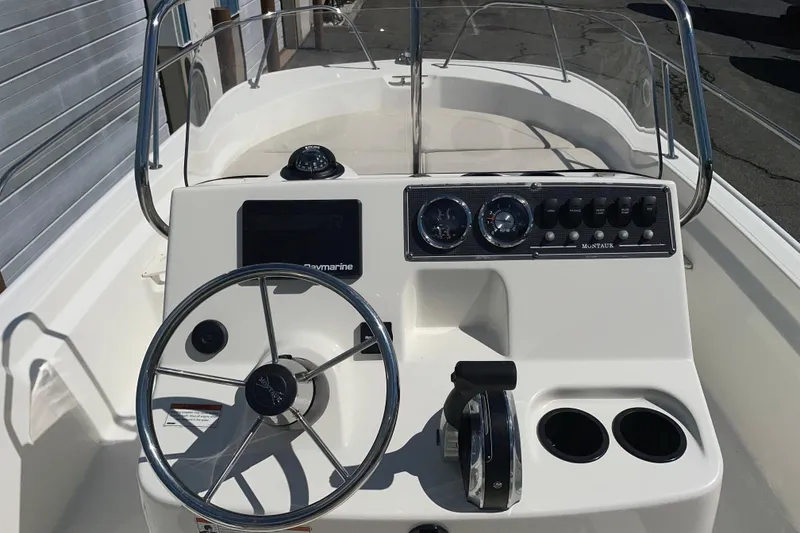 Slide: The Image of 2019 Boston Whaler 190 Montauk boat console with steering wheel and gauges. - 2