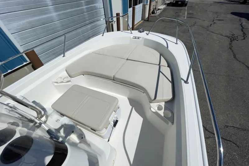 Slide: The Image of 2019 Boston Whaler 190 Montauk boat interior with cushioned seating and stainless steel railings. - 7