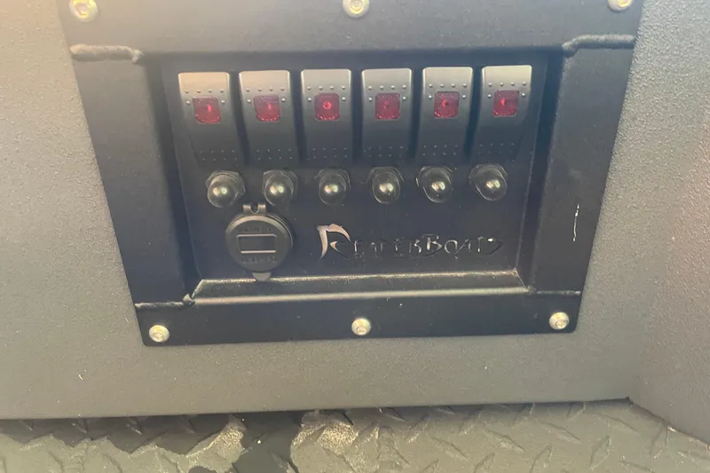 Slide: The Image of Control panel of 2026 Reaper Boats 553 Timber Reaper with switches and USB port. - 14
