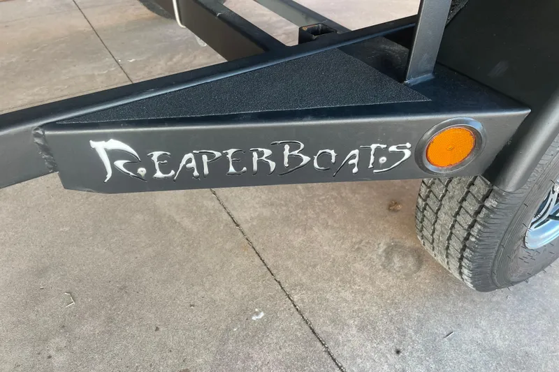 Slide: The Image of Reaper Boats 553 Timber Reaper trailer with logo and orange reflector, 2026 model. - 6