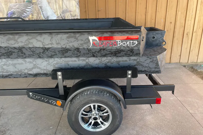 Slide: The Image of 2026 Reaper Boats 553 Timber Reaper on trailer, featuring camouflage design and logo. - 7