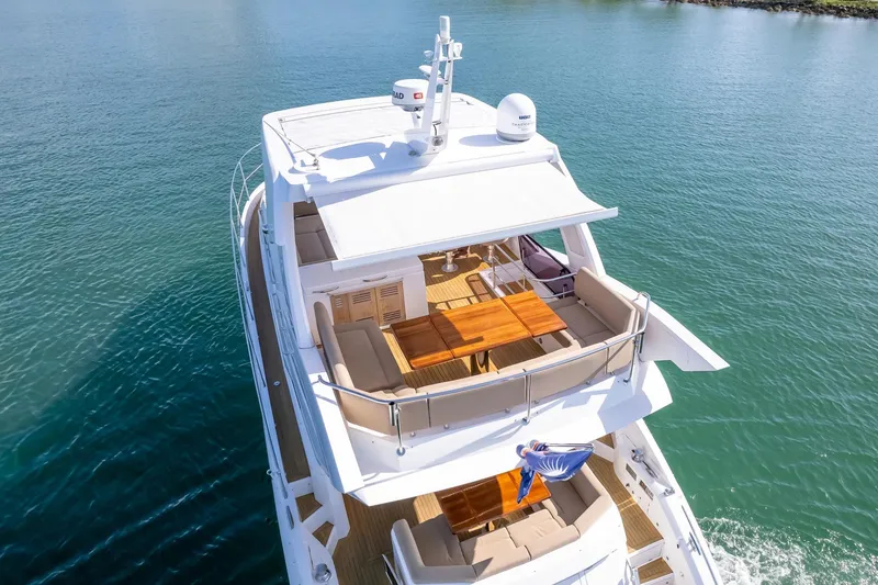 Slide: The Image of 2018 Sunseeker Manhattan 52 yacht with spacious deck and seating, cruising on calm waters. - 17