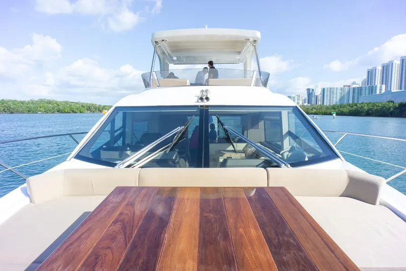 Slide: The Image of 2018 Sunseeker Manhattan 52 yacht with wooden deck, cruising near city skyline. - 25