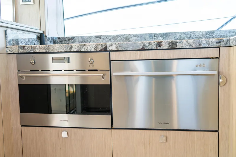 Slide: The Image of Modern kitchen appliances on 2018 Sunseeker Manhattan 52 yacht, featuring stainless steel oven and dishwasher. - 42