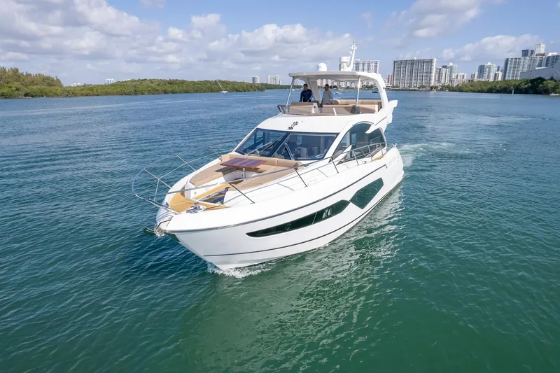 Slide: The Image of 2018 Sunseeker Manhattan 52 yacht cruising on a sunny day with city skyline backdrop. - 5