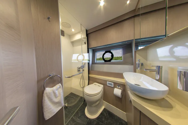 Slide: The Image of Luxurious bathroom on 2018 Sunseeker Manhattan 52 yacht with modern fixtures and porthole window. - 52