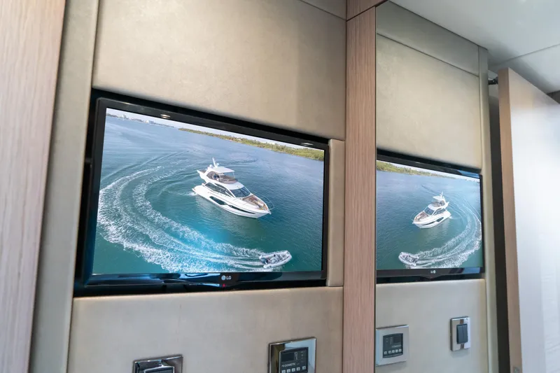 Slide: The Image of Television displaying Sunseeker Manhattan 52 yacht cruising on water, 2018 model. - 67