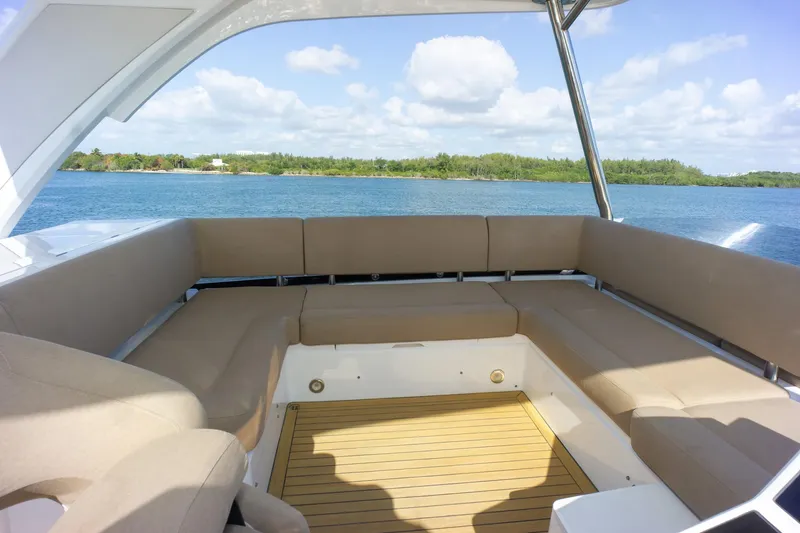 Slide: The Image of Luxurious seating area on 2018 Sunseeker Manhattan 52 yacht, overlooking serene waters. - 81