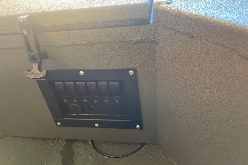 Slide: The Image of Control panel on 2026 Reaper Boats 550 Timber Reaper, featuring multiple switches and a hook. - 16