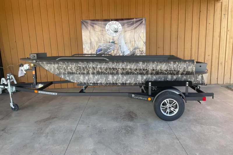 The Image of 2026 Reaper Boats 550 Timber Reaper on trailer, camo design, displayed outdoors. - 2