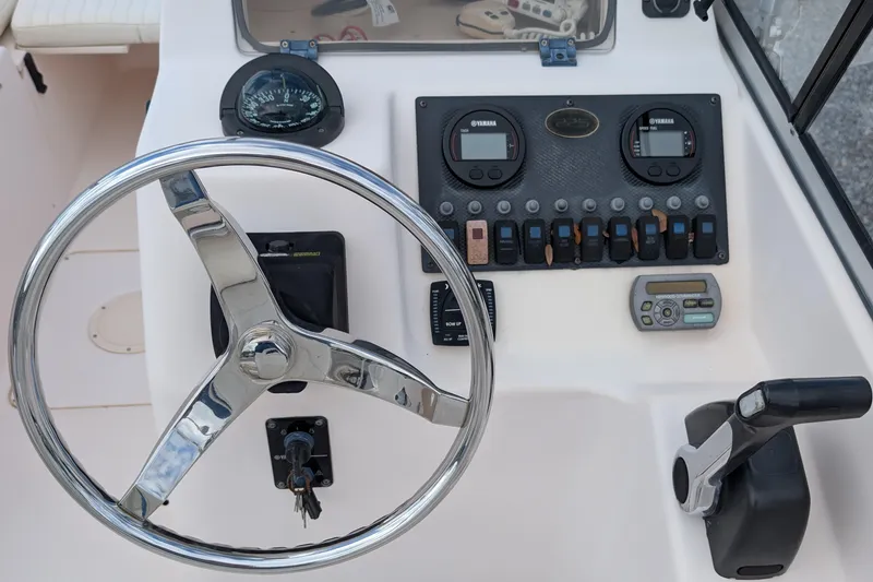 Slide: The Image of 2007 Grady-White Tournament 225 boat dashboard with steering wheel and controls. - 7