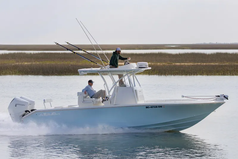 Slide: The Image of 2021 SeaHunter 28 Floridian boat cruising on calm waters with fishing rods. - 1