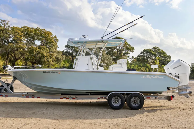Slide: The Image of 2021 SeaHunter 28 Floridian boat on trailer, parked outdoors under a cloudy sky. - 10