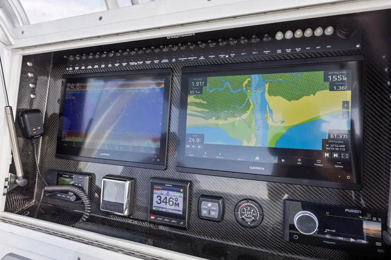 Slide: The Image of 2021 SeaHunter 28 Floridian dashboard with Garmin navigation displays and controls. - 15