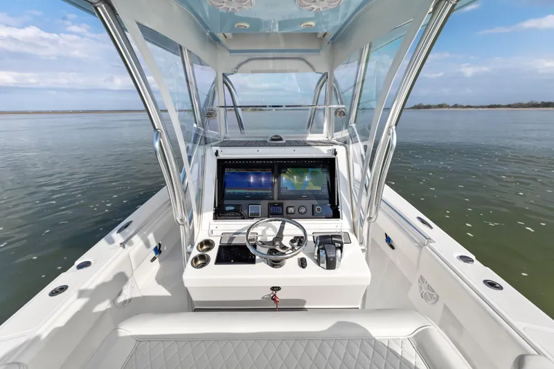 Slide: The Image of 2021 SeaHunter 28 Floridian boat cockpit with advanced navigation system on calm waters. - 19