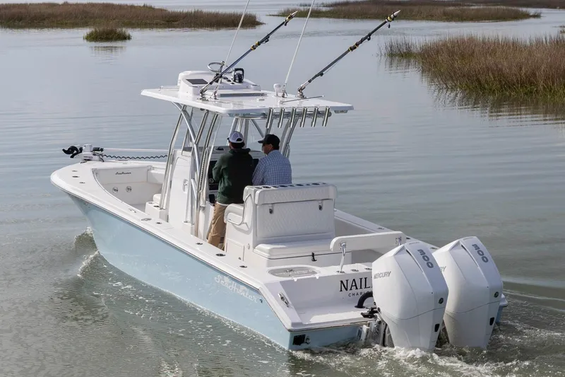 Slide: The Image of 2021 SeaHunter 28 Floridian boat with dual Mercury engines navigating calm waters. - 2