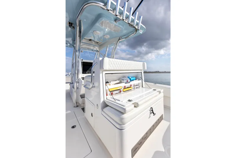 Slide: The Image of 2021 SeaHunter 28 Floridian boat interior with storage compartment open, under a cloudy sky. - 25