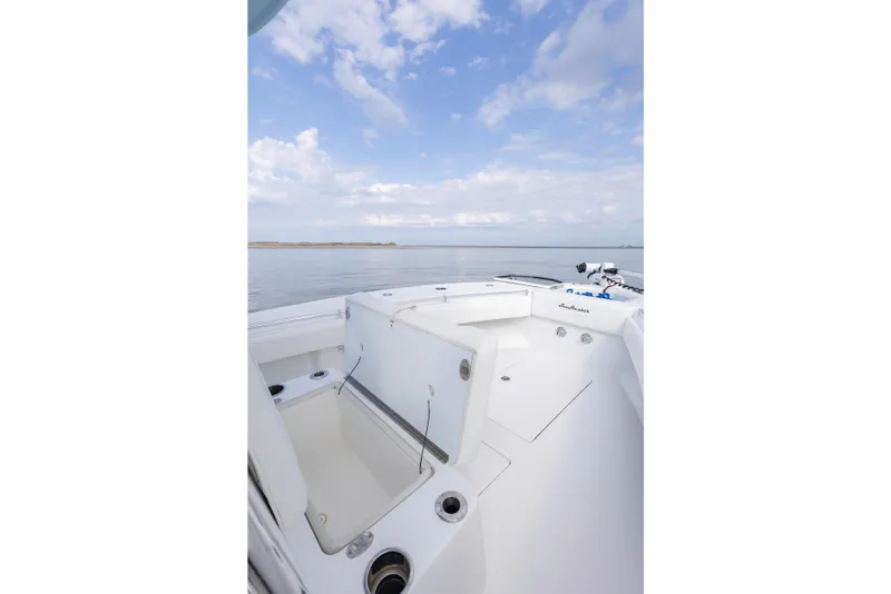 Slide: The Image of 2021 SeaHunter 28 Floridian boat deck with open storage, calm sea, and cloudy sky. - 26