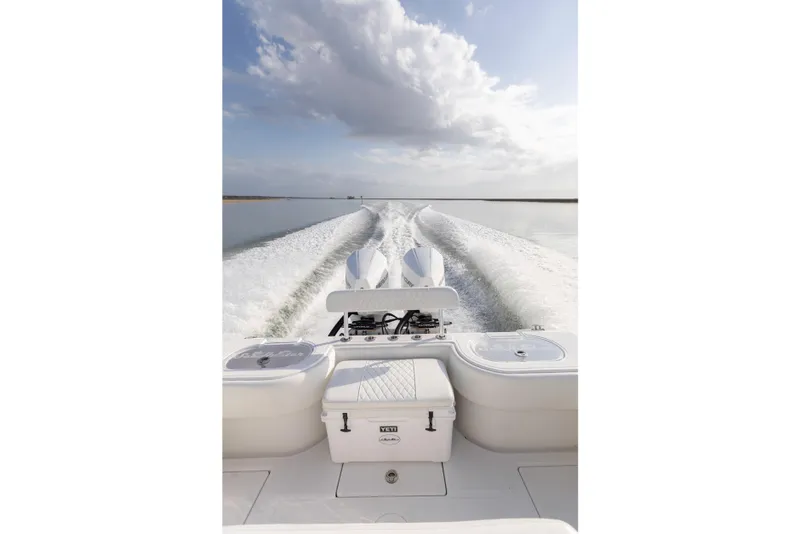 Slide: The Image of 2021 SeaHunter 28 Floridian boat cruising on calm water under a cloudy sky. - 32