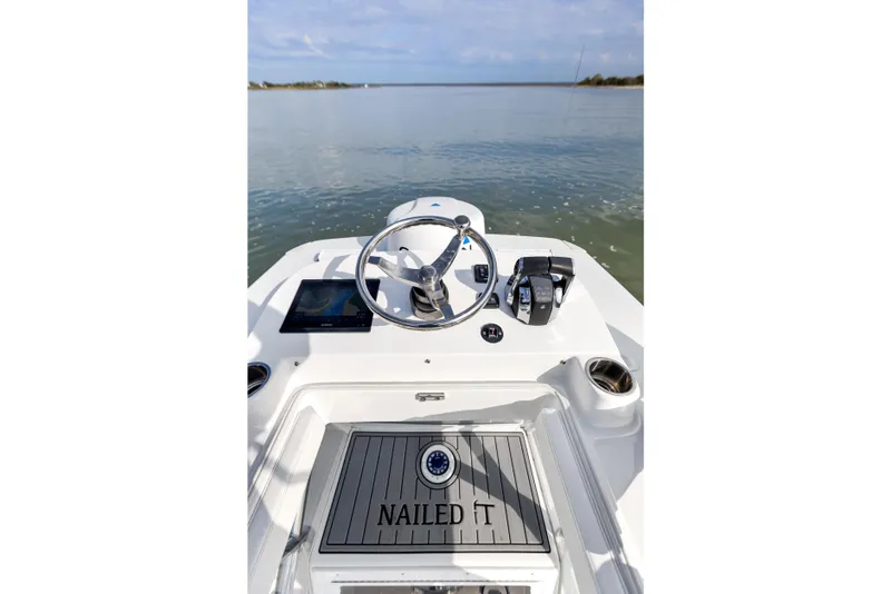 Slide: The Image of 2021 SeaHunter 28 Floridian boat helm with "Nailed It" deck, calm waters ahead. - 33