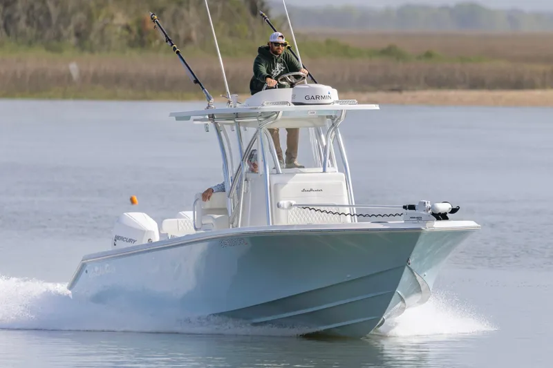 Slide: The Image of 2021 SeaHunter 28 Floridian boat cruising on a calm lake with fishing rods. - 6