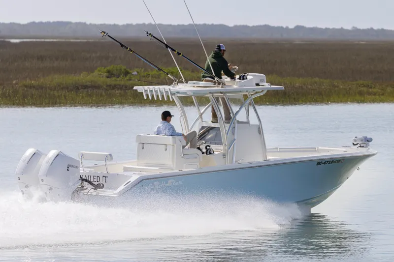 Slide: The Image of 2021 SeaHunter 28 Floridian boat cruising on calm water with two passengers. - 7