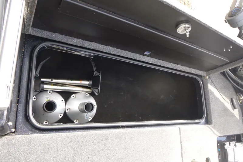 Slide: The Image of Open storage compartment in 2019 Triton 206 Allure boat, showing metal components inside. - 12
