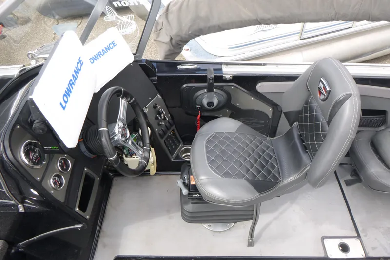 Slide: The Image of 2019 Triton 206 Allure boat cockpit with steering wheel, Lowrance display, and cushioned seat. - 13
